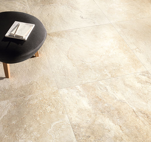 Immagine in primo piano del pavimento di un living in un moderno appartamento, serie Bloom colore Beige
