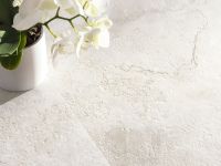 Particolare del pavimento Bloom White con vaso di fiori appoggiato